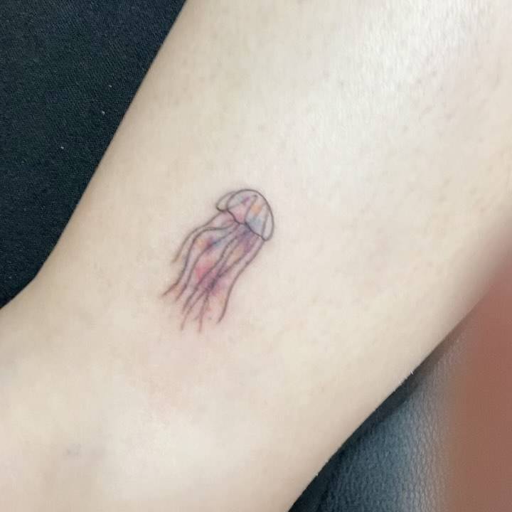 Illustrative style jellyfish tattoo placed on the ankle.