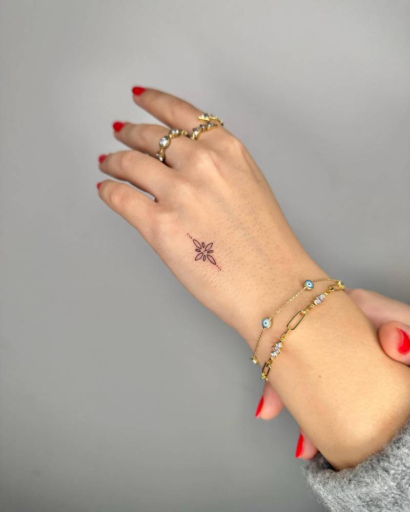 Fine line style ornamental tattoo located on the hand.