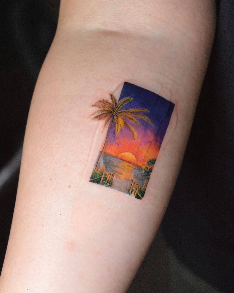 Watercolor style beach sunset tattoo located on the calf.