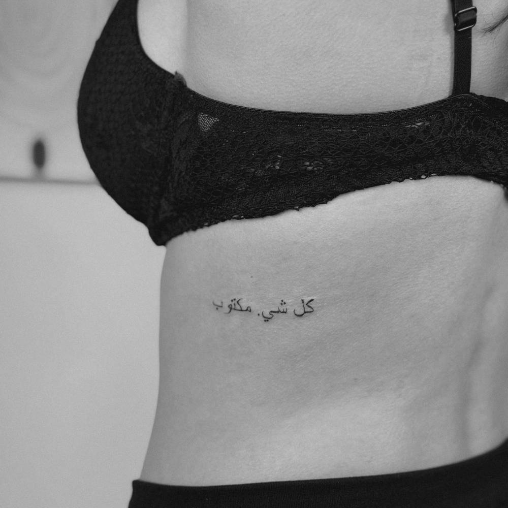 Arabic lettering tattoo located on the back.