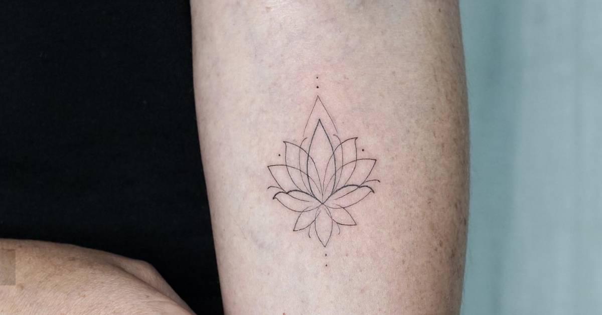 Little fine line lotus flower tattoo located on the