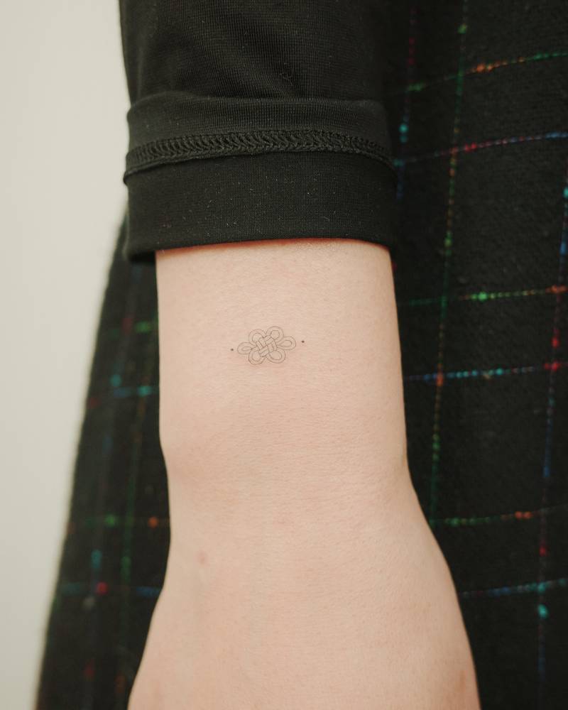 Fine line style Korean knot tattoo placed on the wrist.