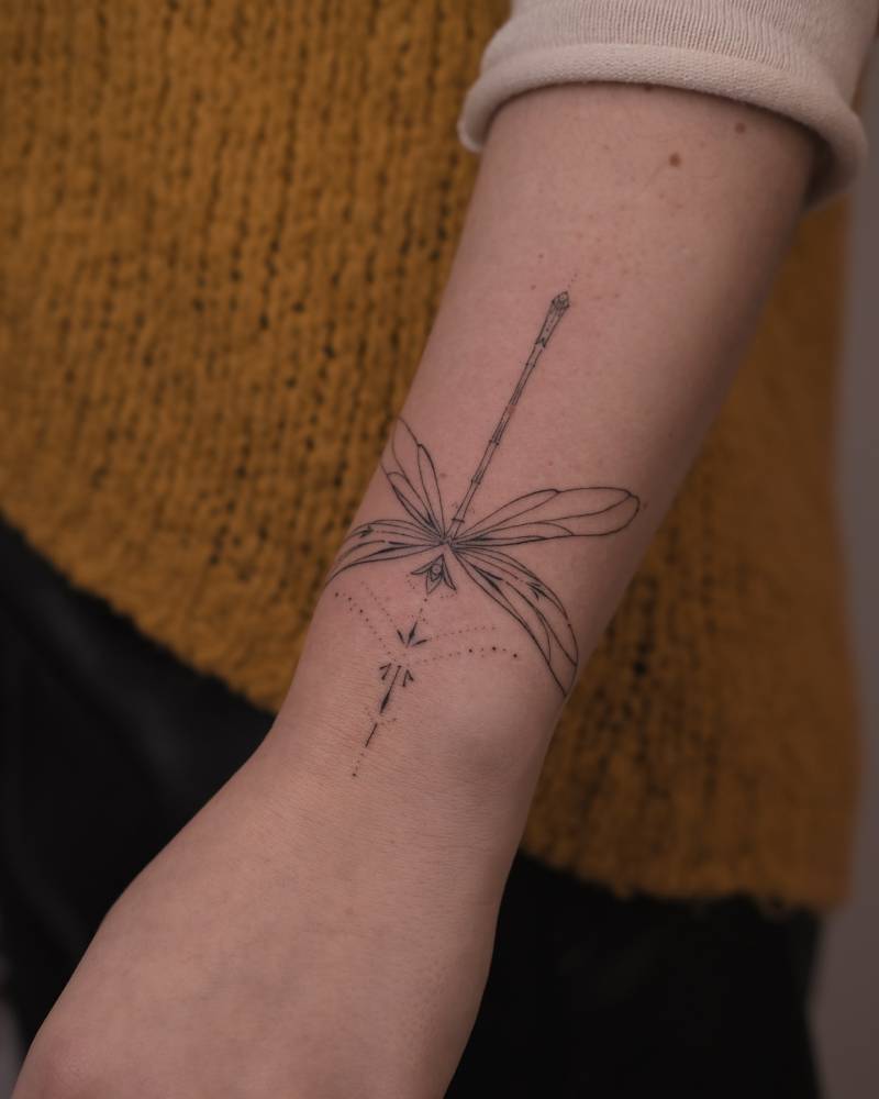 Hand poked dragonfly tattoo located on the wrist.