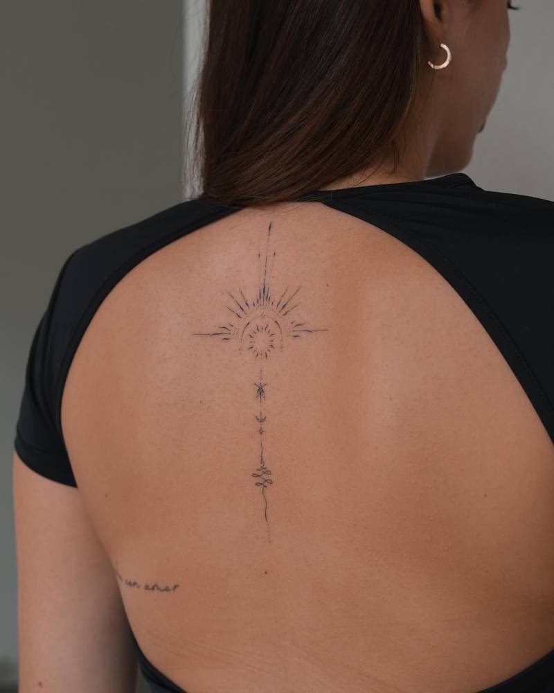 Hand poked style ornamental tattoo located on the upper back.