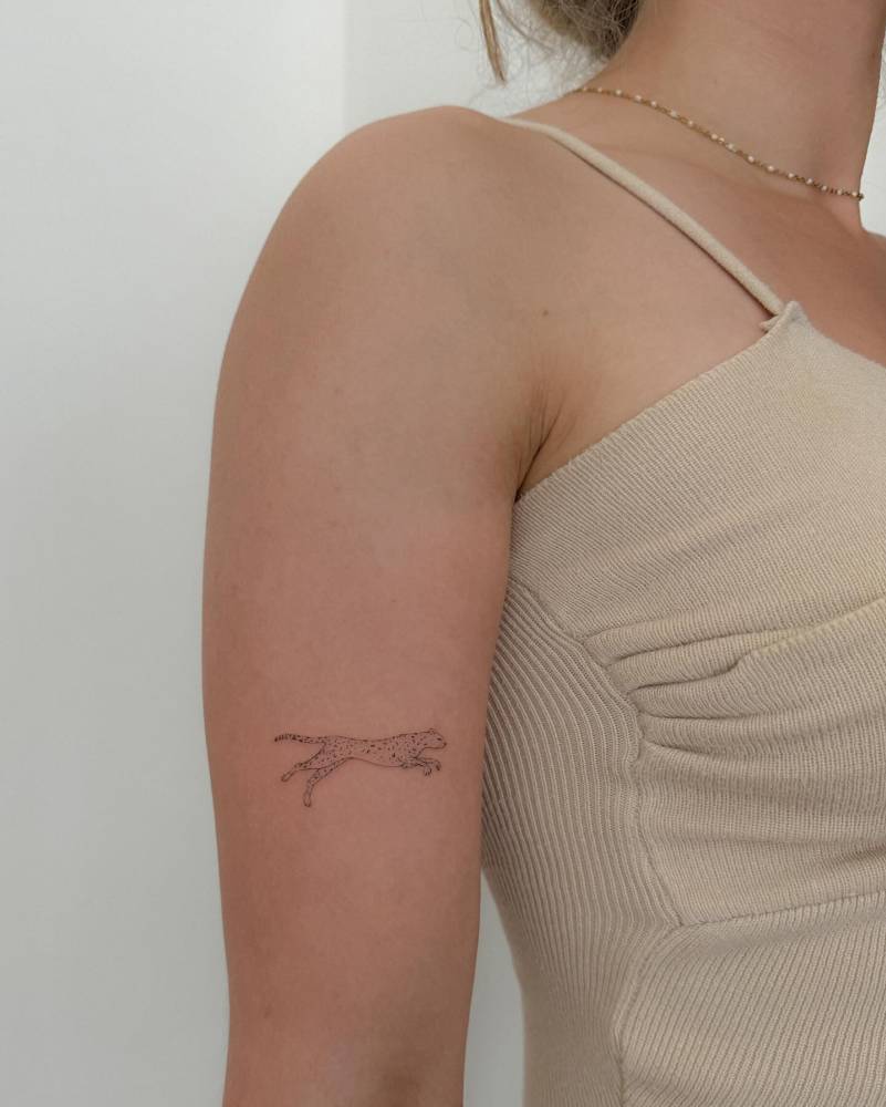 Leopard tattoo located on the upper arm, done in illustrative style.