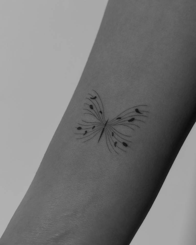 Single needle abstract butterfly tattoo done on the inner forearm.