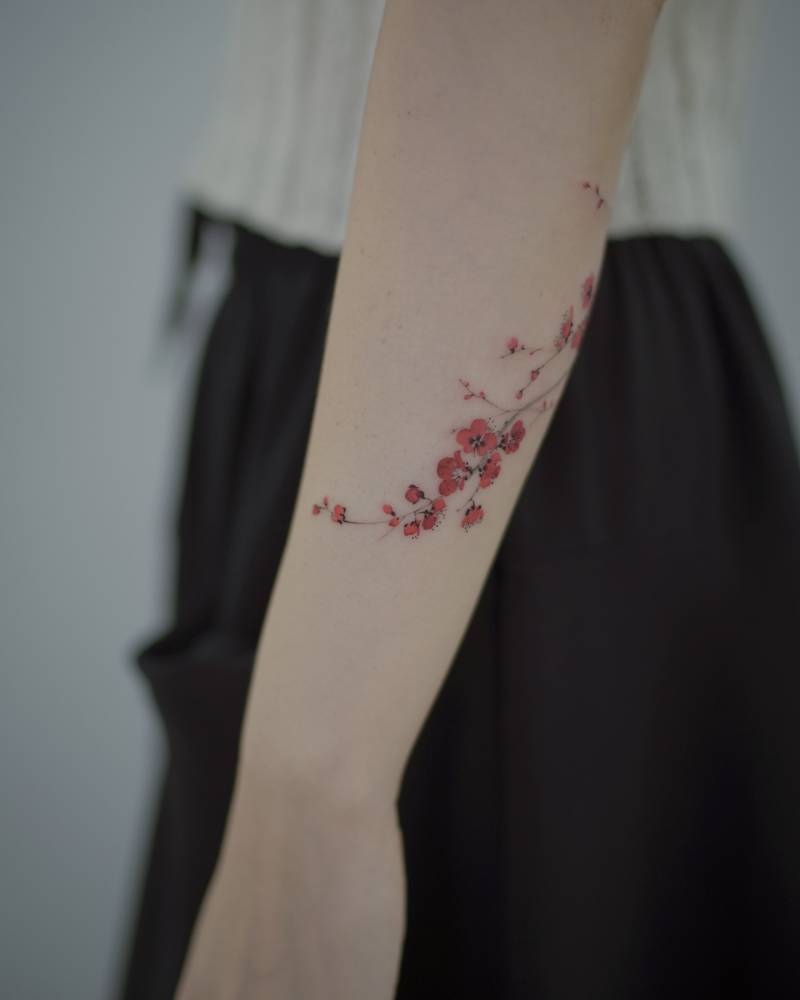 Micro-realistic style apricot blossom tattoo located on the forearm.