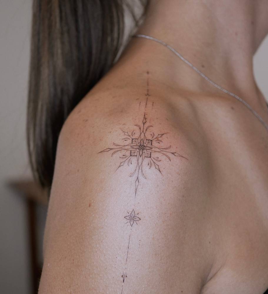 Fine line style ornamental tattoo placed on the shoulder.