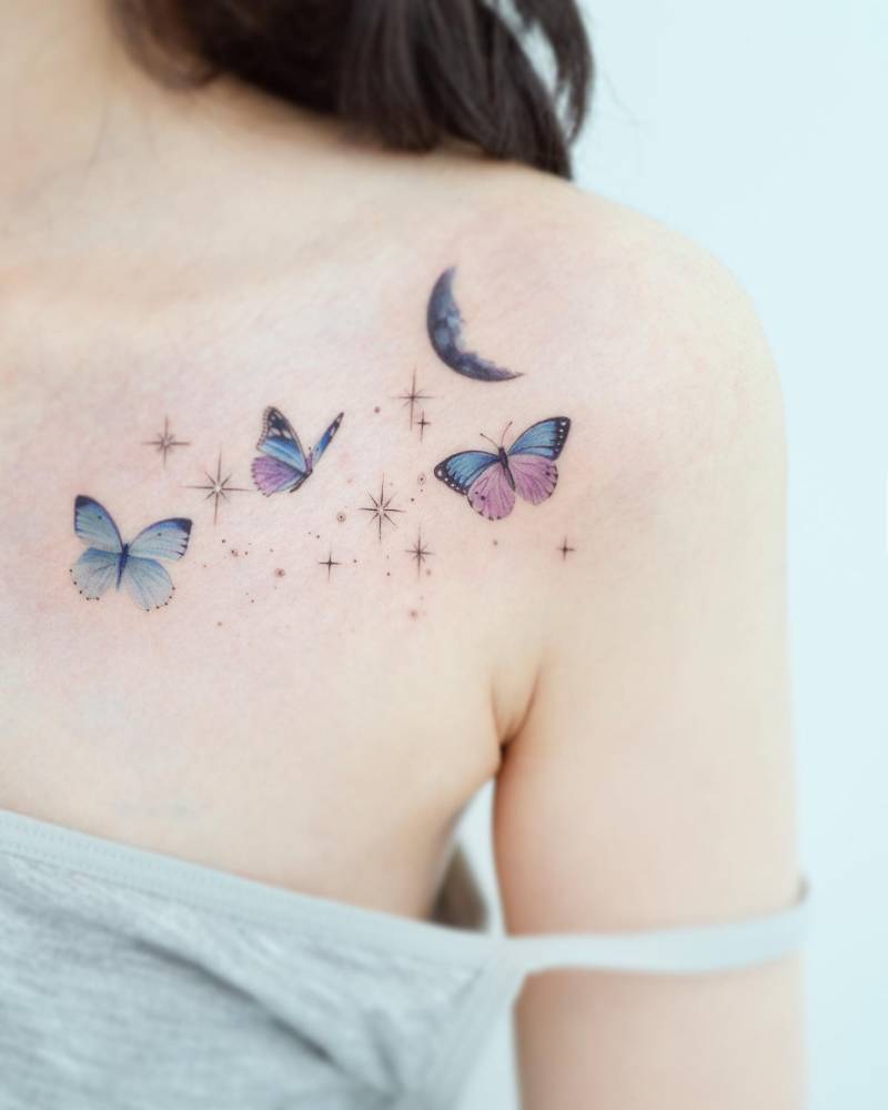 Watercolor style butterflies tattoo located on the collarbone.