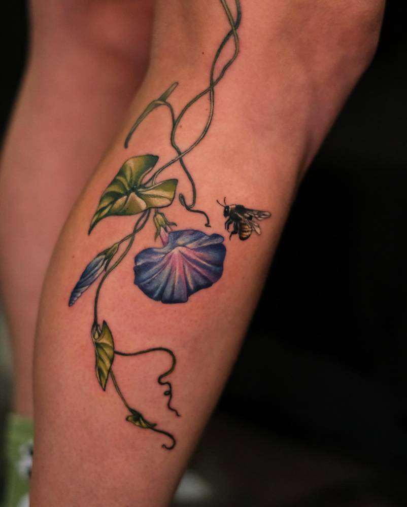 Morning glory flowers and bee tattoo located on the calf, illustrative style