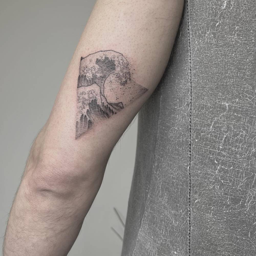 Hokusai's 'Great Wave' tattoo located on the tricep.