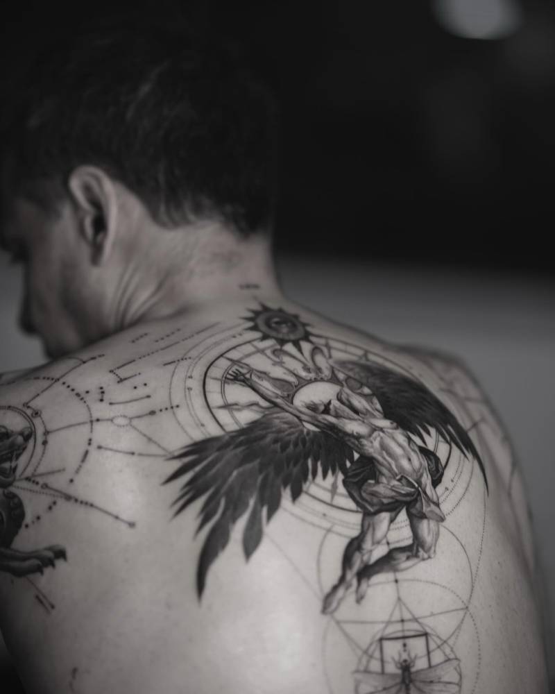 Black and grey "Evening: Fall of Day" lettering tattoo placed on the back.