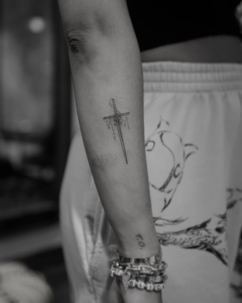 Single needle sword tattoo located on the forearm.