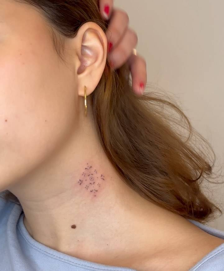 Ornamental tattoo located on the neck, fine line style.