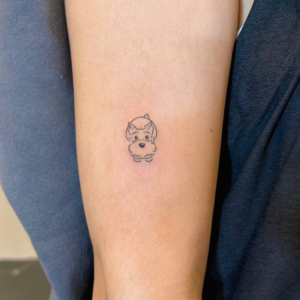 Hand poked schnauzer tattoo located on the upper arm.