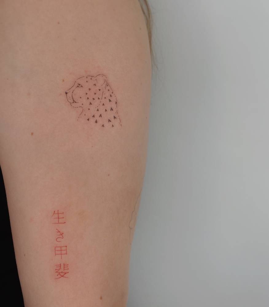 Leopard portrait tattoo located on the upper arm.