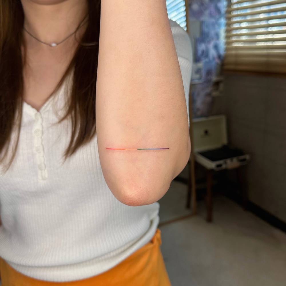 Visible spectrum line tattoo placed on the elbow.