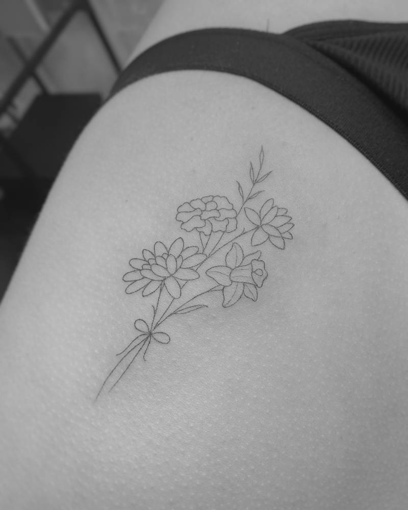 Fine line style flower bouquet tattoo located on the rib.