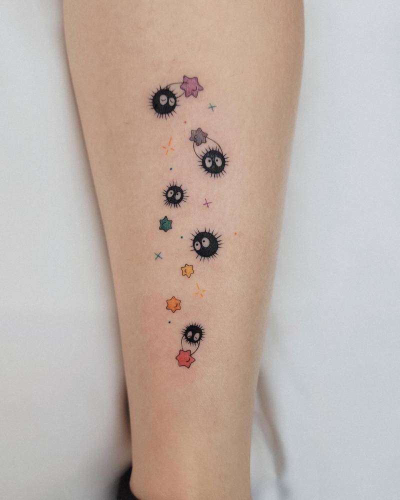 Soot Sprites tattooed on the shin, cartoon style.