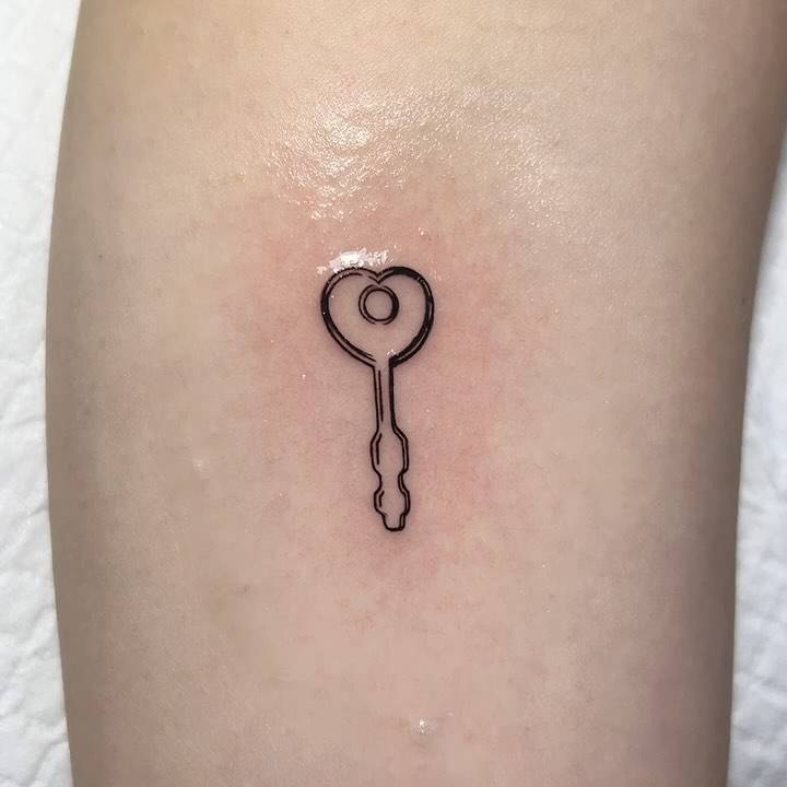 Heart key tattoo done on the inner arm, fine line style.