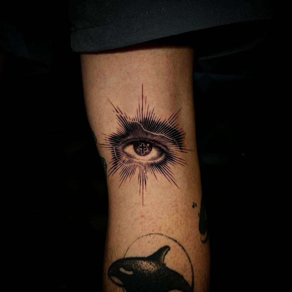 Blackwork style eye tattoo located on the upper arm.