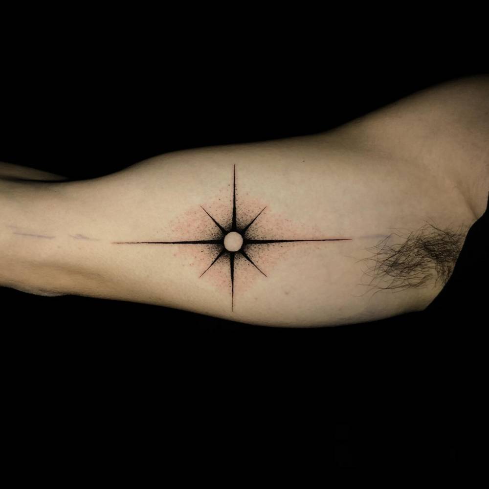 North star tattoo in blackwork style done on the inner arm.