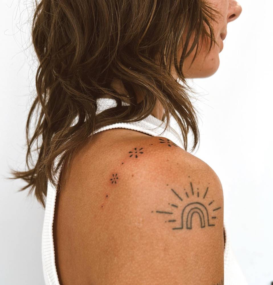 Hand poked flower ornaments tattoo located on the shoulder.