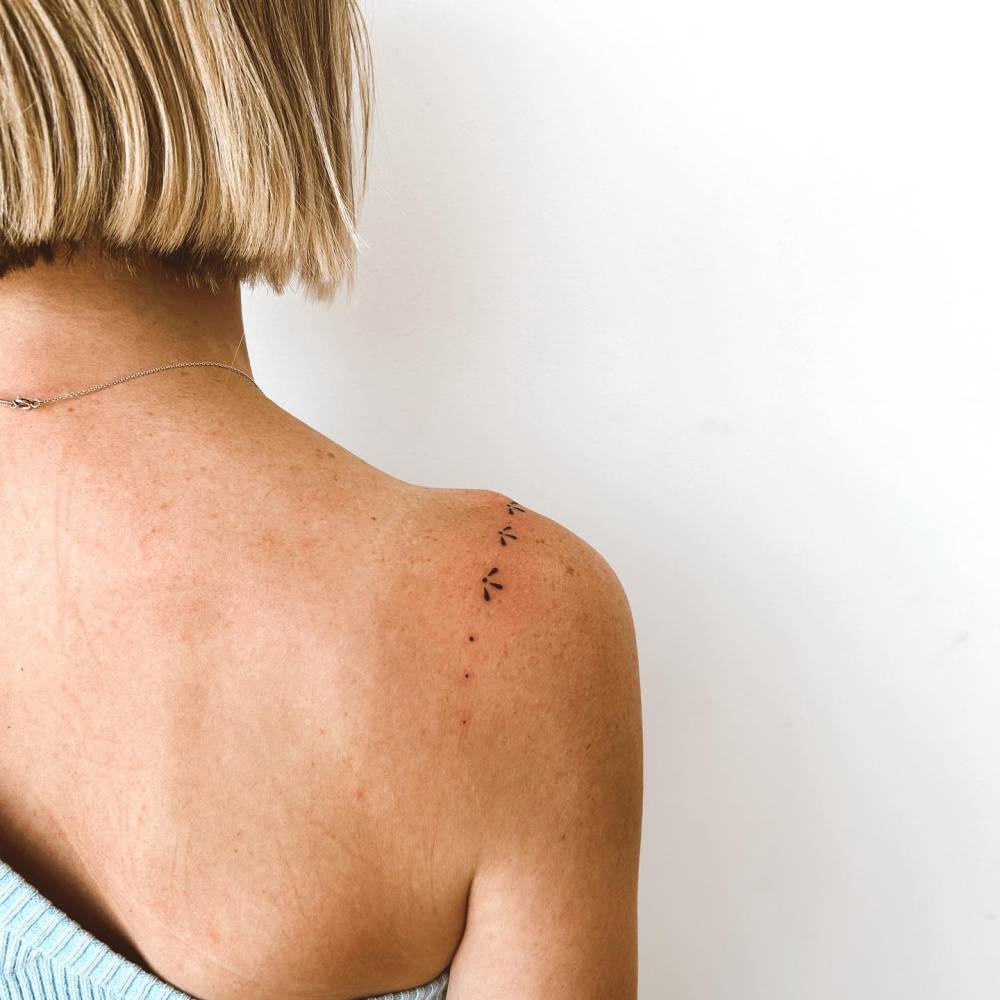 Hand poked ornaments tattoo located on the shoulder.