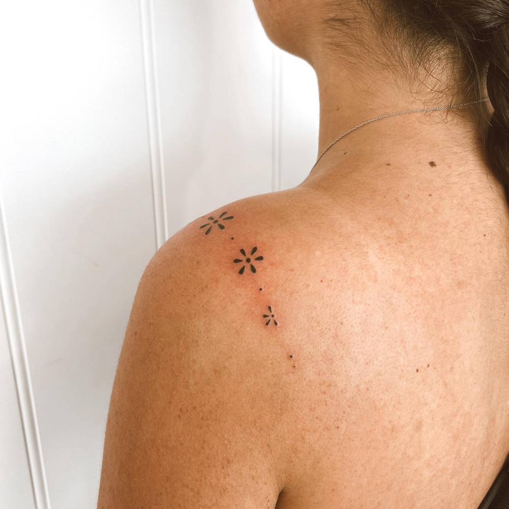 Flower ornament tattoo hand poked on the shoulder.