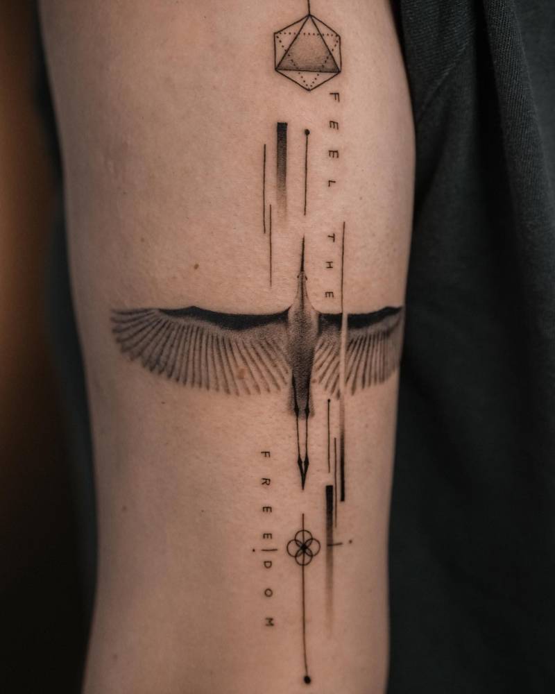 Chinese egret graphic tattoo located on the tricep.