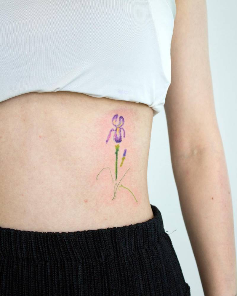 Iris flower tattoo placed on the rib, watercolor style.