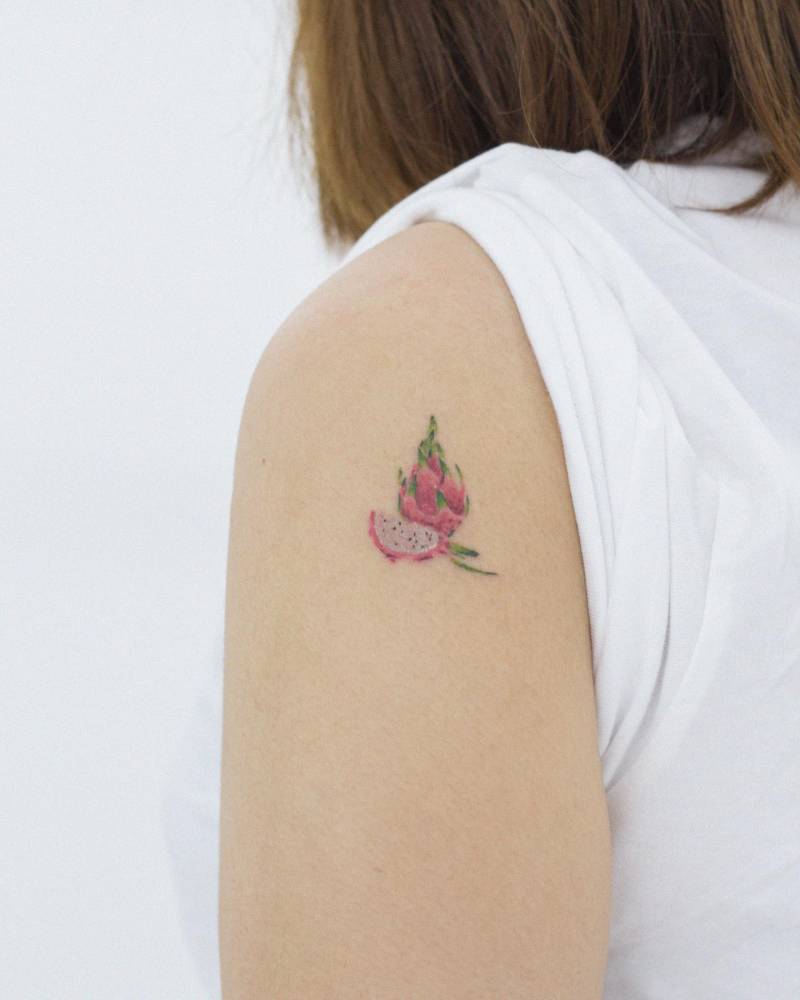 Watercolor style dragon fruit tattoo located on the upper arm.