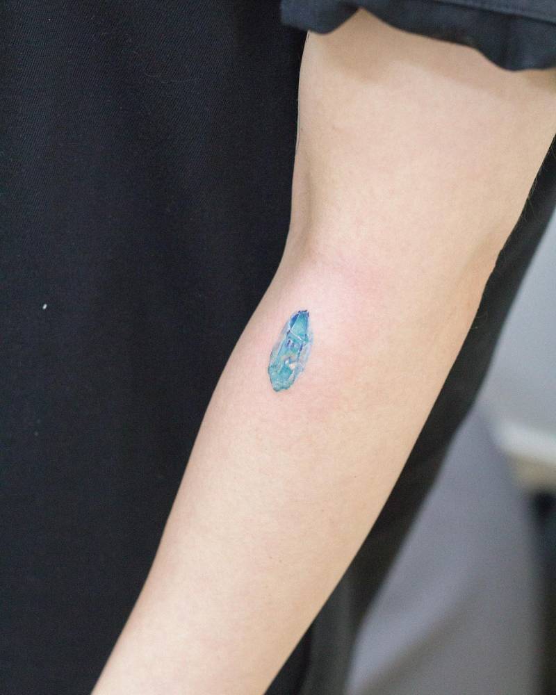 Aqua Aura Quartz tattooed on the forearm, watercolor style.