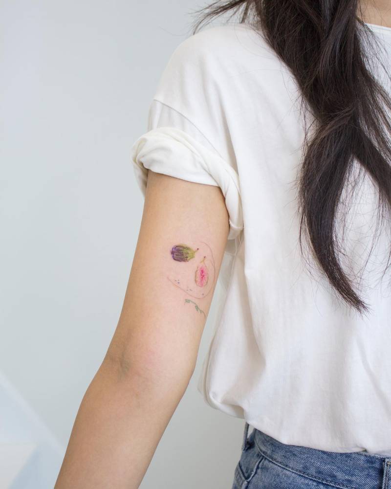 Watercolor style fig tattoo located on the inner arm.