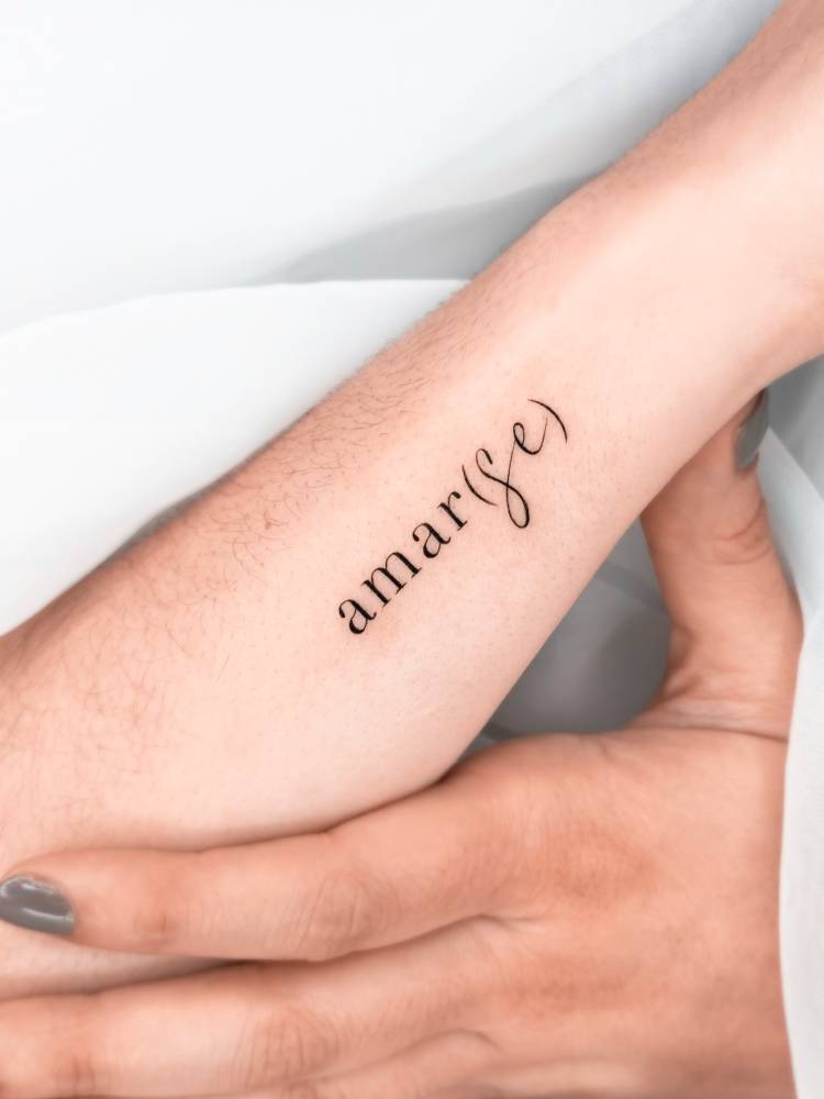 "Amar(se)" lettering tattoo located on the wrist.