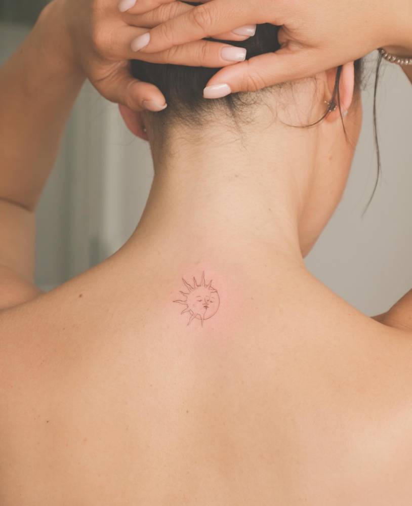 Kissing sun and moon tattoo located on the upper back.