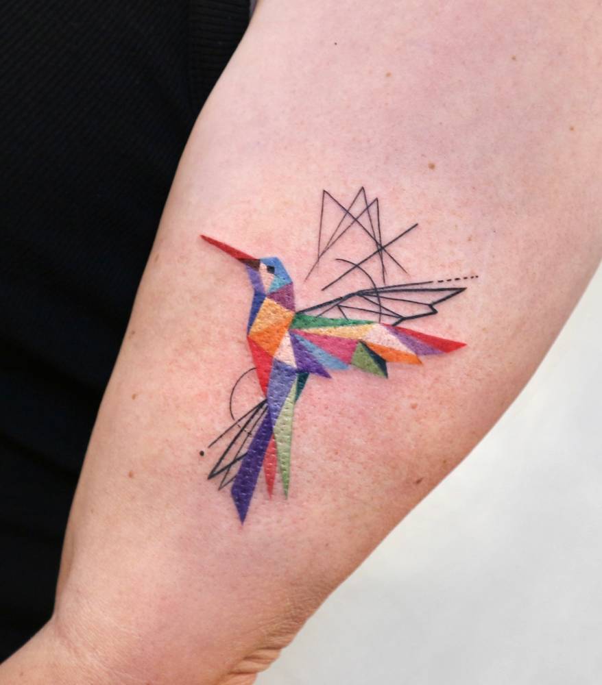 Pop art style low poly hummingbird tattoo located on the upper arm.