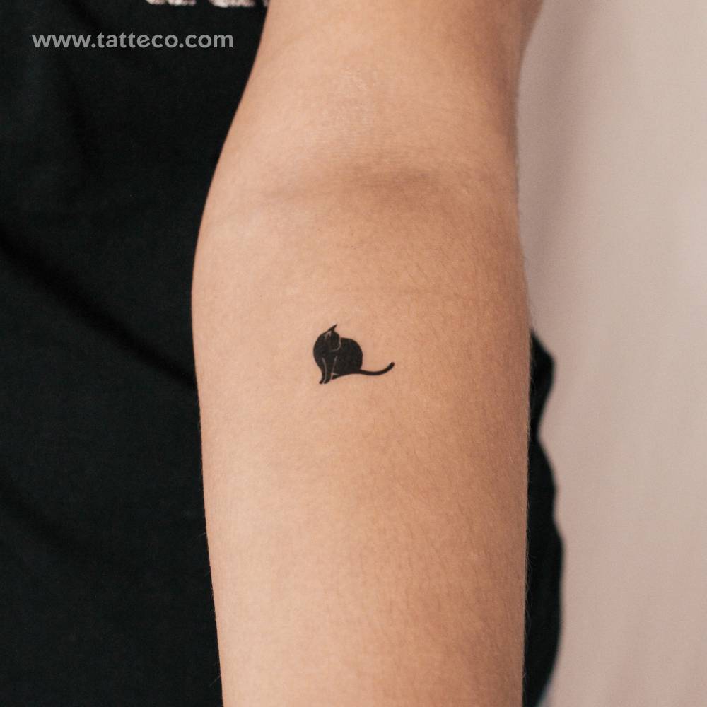 Standing black cat semi-permanent tattoo located on the inner forearm.