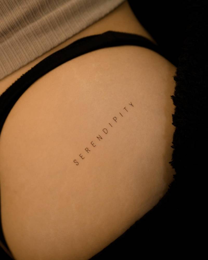"Serendipity" lettering tattoo done on the hip.