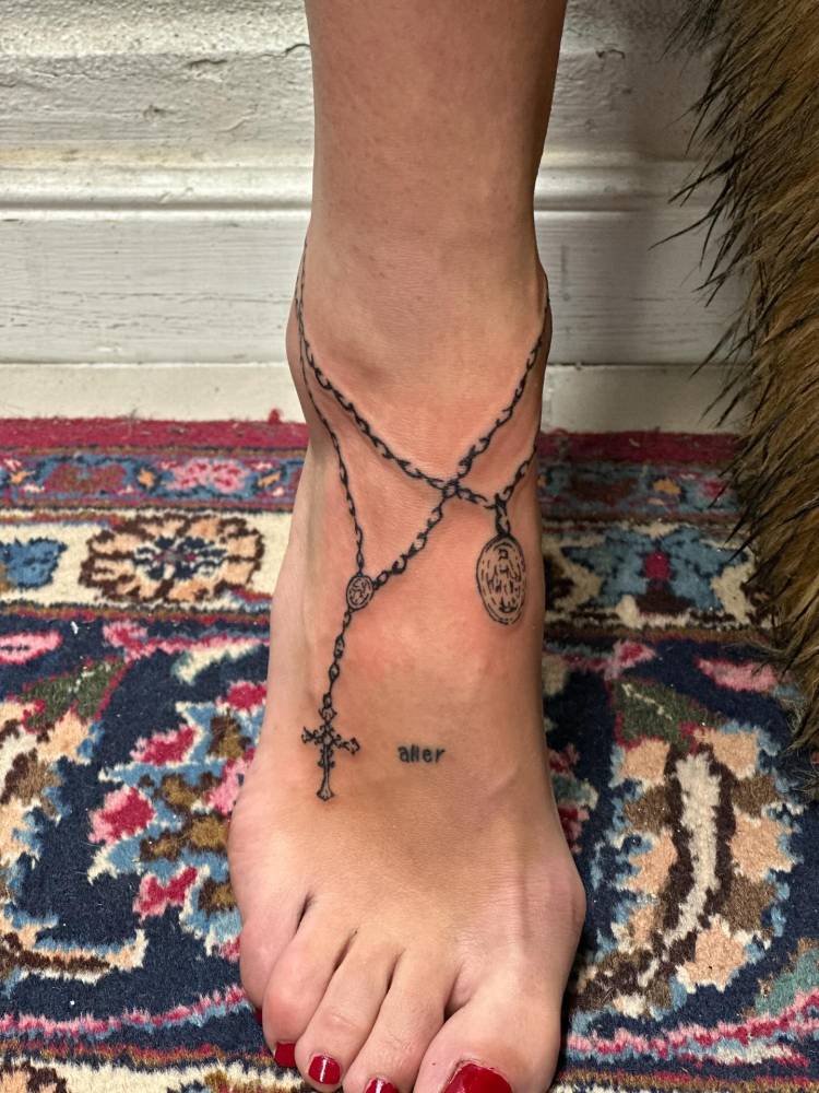 Rosary tattoo located on the ankle and foot.