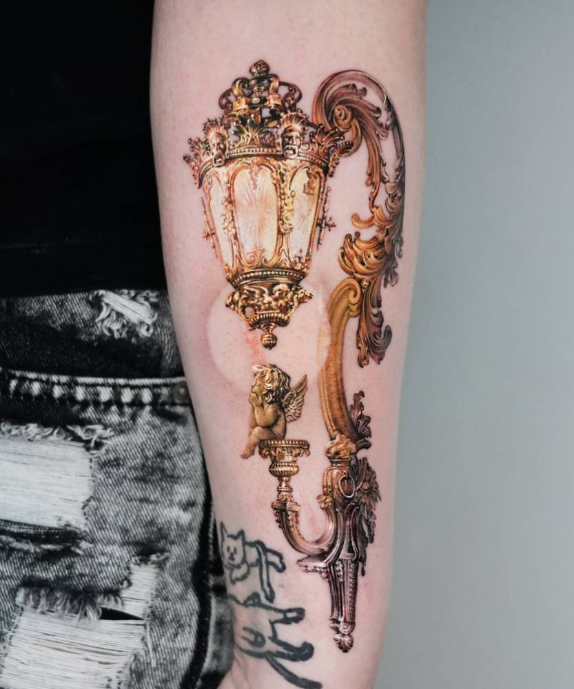 Micro-realistic style wall lantern tattoo located on the inner forearm.