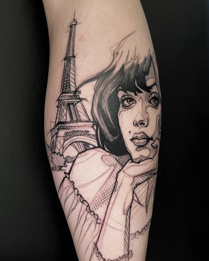 Sketch work style woman portrait and Eiffel Tower tattooed on the calf.