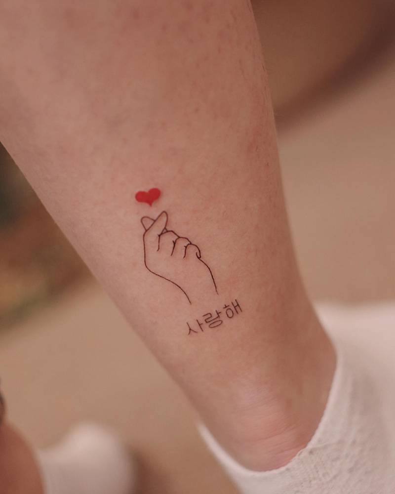Korean finger heart tattoo located on the achilles.