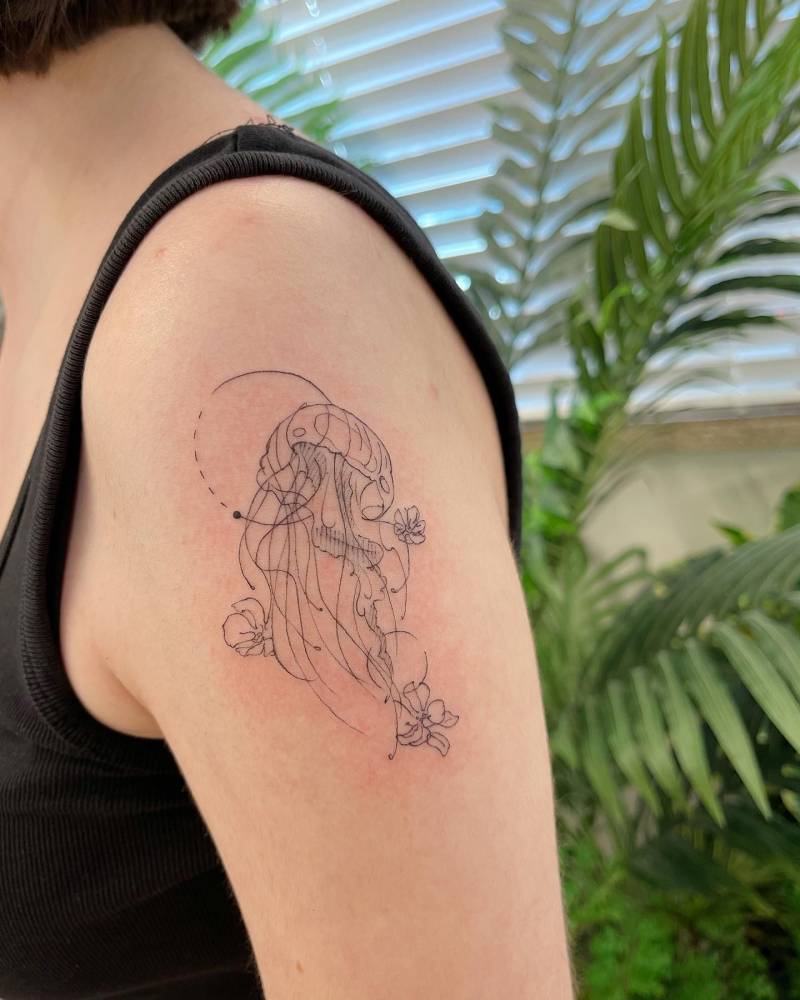 Jellyfish tattoo in fine line style located on the upper arm.