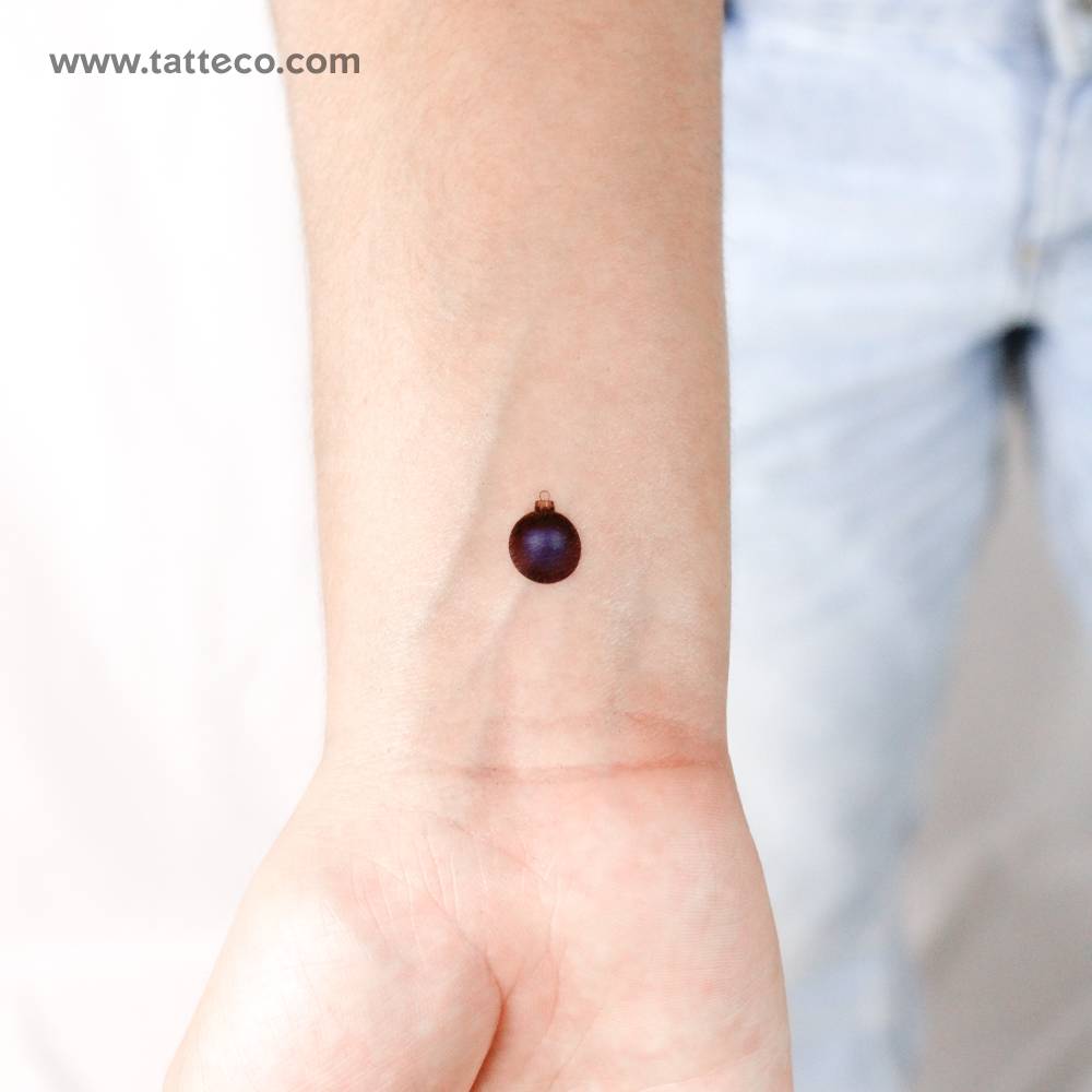 Blue Christmas bauble temporary tattoo located on the wrist.