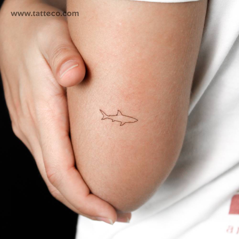 Fine line style minimalistic shark semi-permanent tattoo located on the tricep.