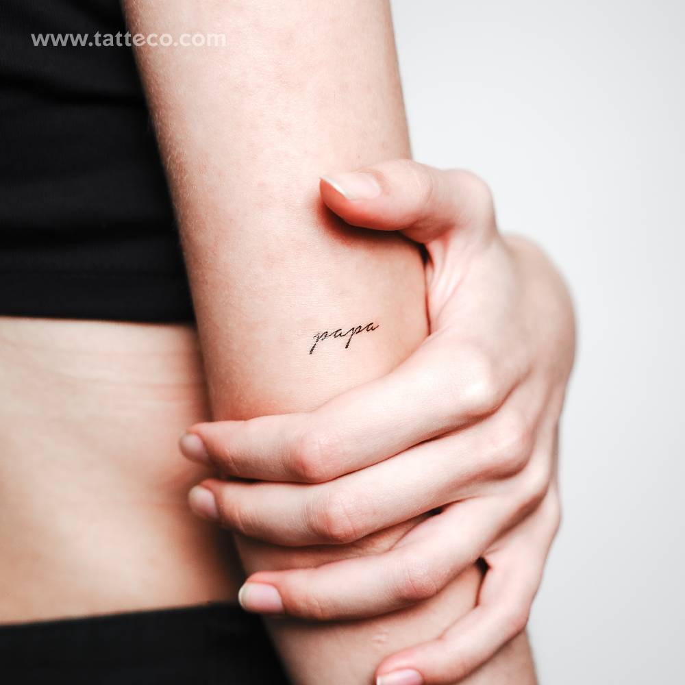 Little word "papa" temporary tattoo located on the tricep.