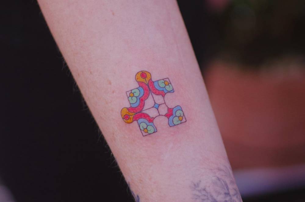 Illustrative style puzzle piece tattoo done on the inner forearm.