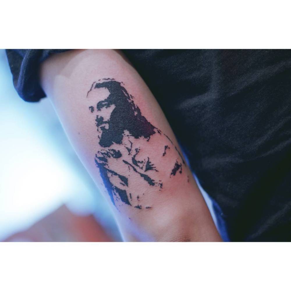 Jesus Christ portrait tattoo in stencil style located on the tricep.