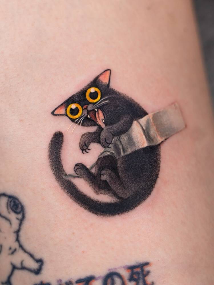 Trippy cat tattoo located on the thigh, cartoon style.